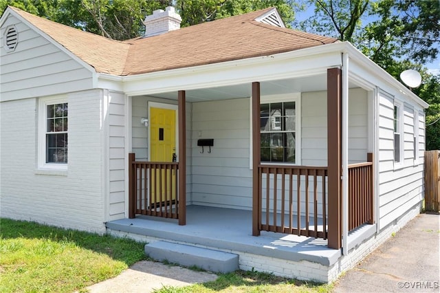 3507 Howard Rd, Henrico, VA 23223 - view of front facade with covered porch, a chimney, roof with shingles, and brick siding