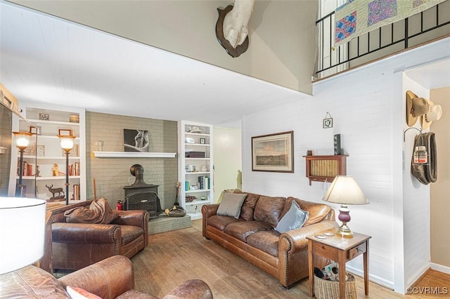 15019 Quaker Church Rd, Montpelier, VA 23192 - living area featuring a wood stove, built in features, wood finished floors, baseboards, and a high ceiling