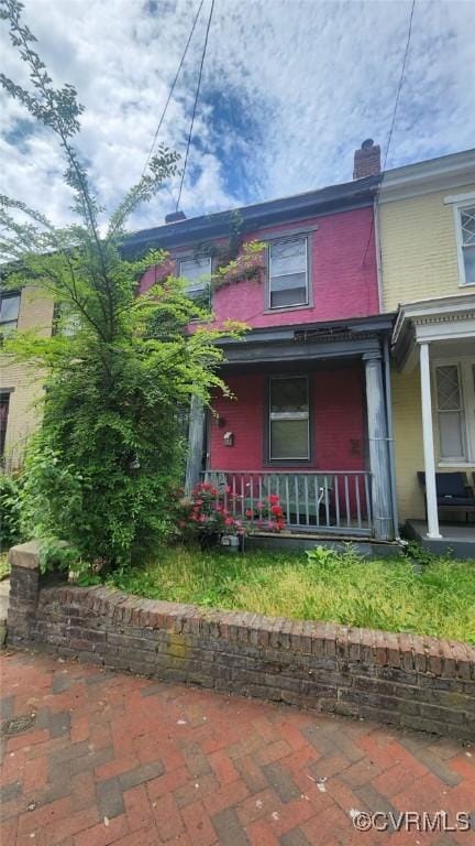 213 E Leigh St, Richmond, VA 23219 - view of front facade with a porch, a chimney, and brick siding