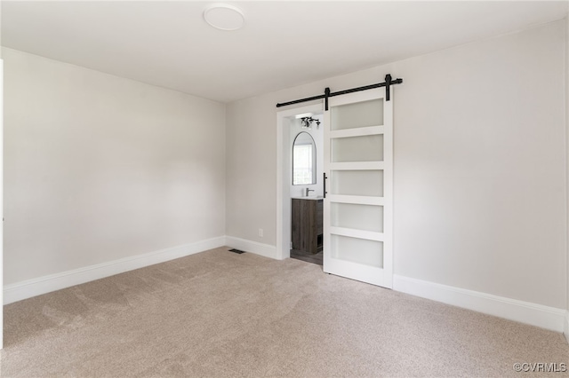 701 Nottoway Ave, Blackstone, VA 23824 - empty room with carpet, a barn door, and baseboards