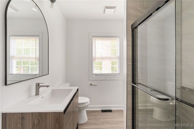 701 Nottoway Ave, Blackstone, VA 23824 - bathroom with toilet, wood finished floors, vanity, a shower stall, and baseboards