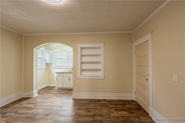 89 N Main St, Kilmarnock, VA 22482 - unfurnished room with dark wood-style flooring, arched walkways, ornamental molding, built in shelves, and baseboards