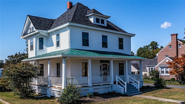89 N Main St, Kilmarnock, VA 22482 - country-style home with a porch, metal roof, a chimney, and a front lawn