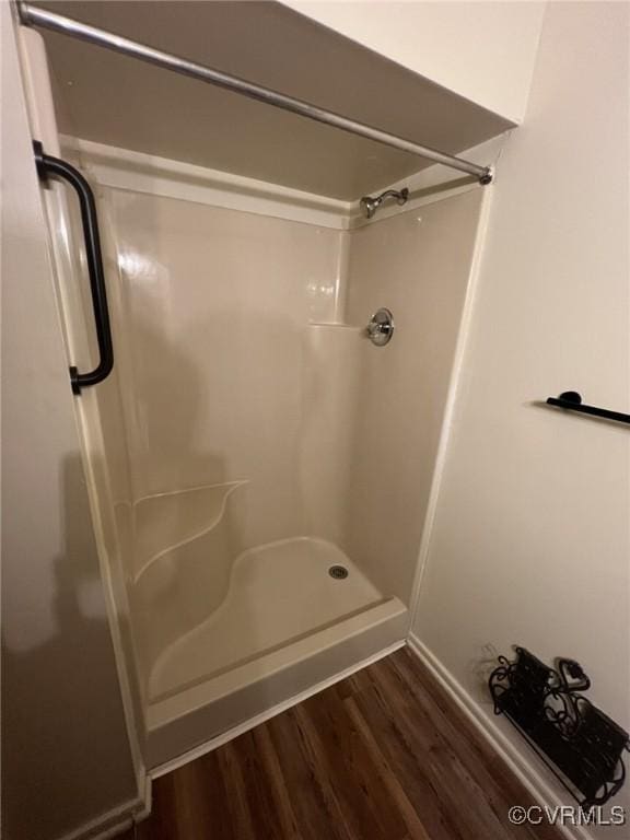 full bath featuring a shower stall and wood finished floors