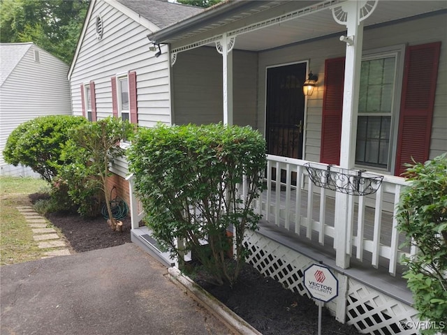 view of exterior entry featuring covered porch