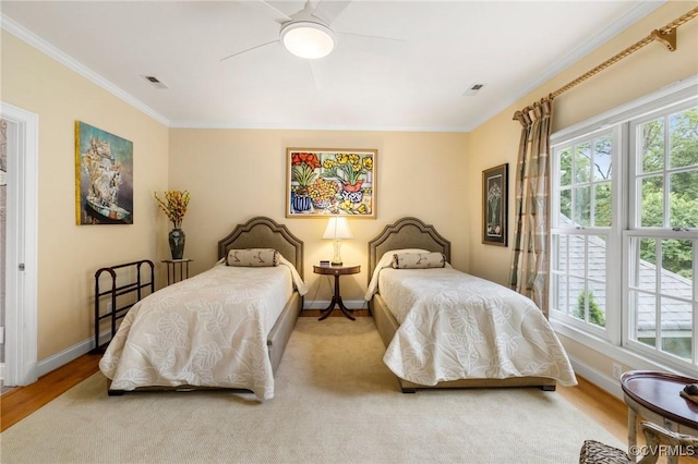 bedroom with multiple windows, baseboards, crown molding, ceiling fan, and wood finished floors