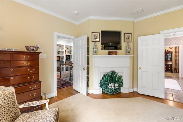 living area featuring crown molding, wood finished floors, and baseboards