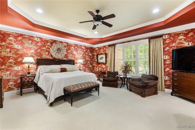 carpeted bedroom with ornamental molding, a tray ceiling, a ceiling fan, recessed lighting, and wallpapered walls