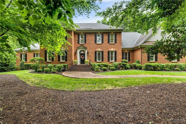 view of front facade featuring brick siding and a front lawn