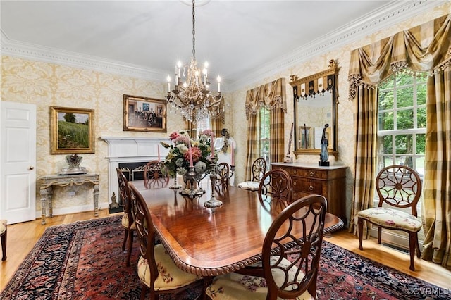 dining area with a chandelier, wallpapered walls, crown molding, and light wood-type flooring