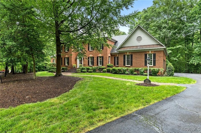 view of front of home with brick siding and a front lawn