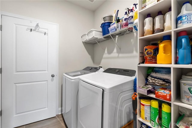 laundry area featuring washer and dryer and wood finished floors
