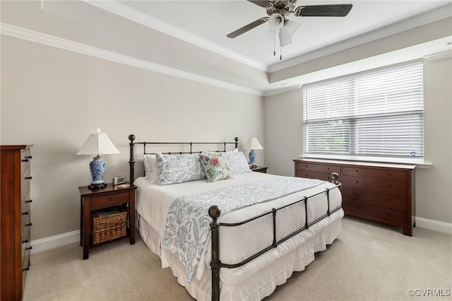 bedroom with light carpet, baseboards, ornamental molding, a tray ceiling, and a ceiling fan