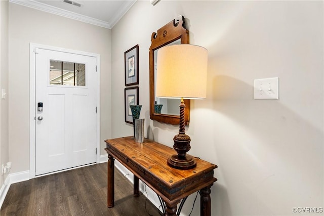foyer entrance featuring ornamental molding, dark wood-style flooring, and baseboards