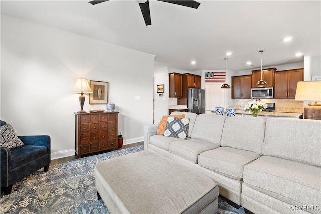 living room with ceiling fan, baseboards, recessed lighting, and dark wood finished floors
