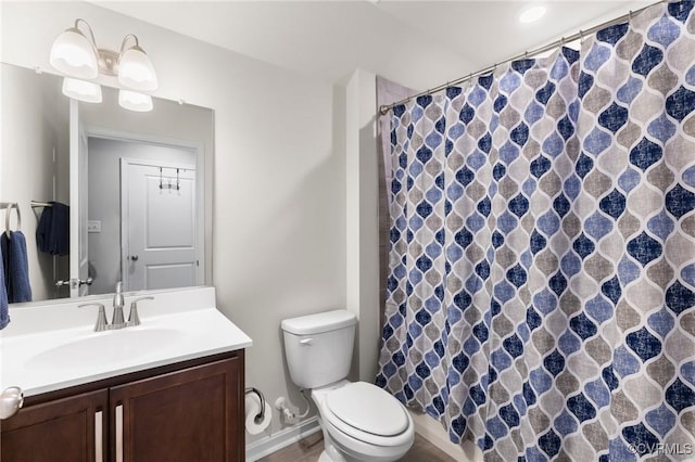 bathroom featuring toilet, vanity, and a shower with shower curtain