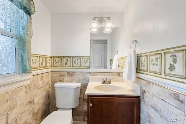 10970 Haverford Ln, North Chesterfield, VA 23236 - half bathroom featuring toilet, vanity, a chandelier, wainscoting, and tile walls