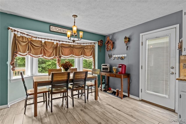 14125 Mountain Rd, Glen Allen, VA 23059 - dining space with light wood finished floors, a textured ceiling, baseboards, and a chandelier