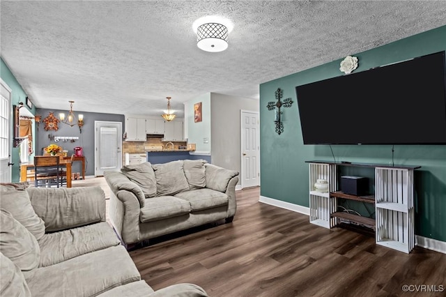 14125 Mountain Rd, Glen Allen, VA 23059 - living room featuring a chandelier, dark wood finished floors, baseboards, and a textured ceiling