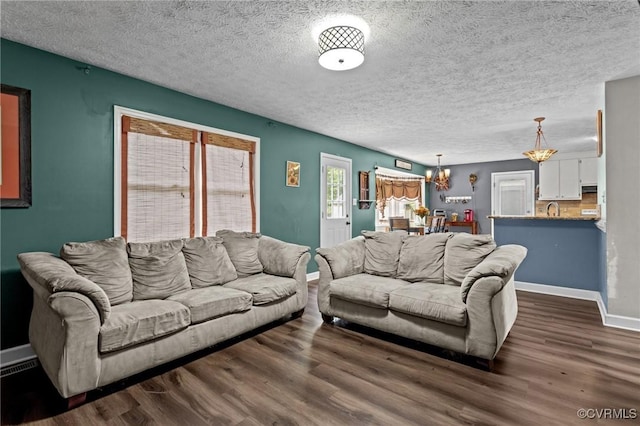 14125 Mountain Rd, Glen Allen, VA 23059 - living area with a chandelier, dark wood-style flooring, baseboards, and a textured ceiling