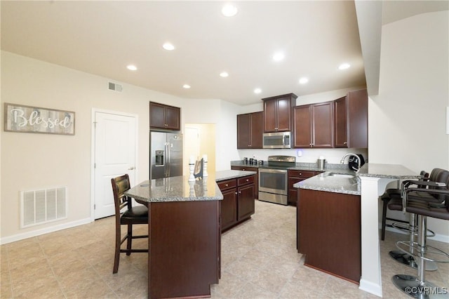 9006 Proctors Run Ct, Chesterfield, VA 23237 - kitchen with stainless steel appliances, a kitchen bar, a sink, light stone counters, and recessed lighting