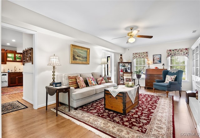 living area with light wood finished floors and ceiling fan