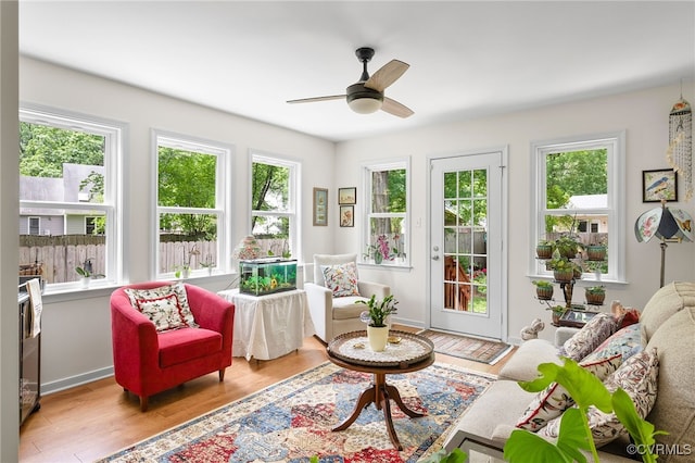 living area featuring a ceiling fan and wood finished floors