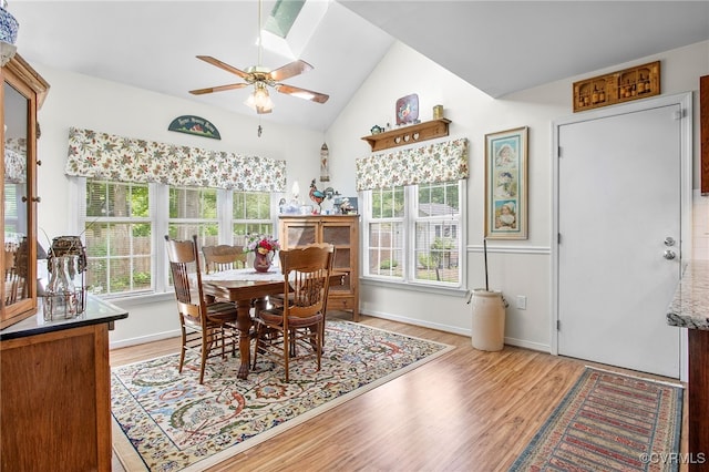 dining area featuring a ceiling fan, light wood-type flooring, and lofted ceiling