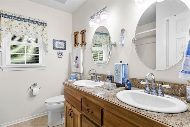 full bath featuring toilet, tile patterned floors, double vanity, and baseboards