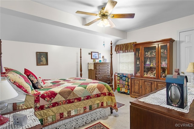 carpeted bedroom with ceiling fan and vaulted ceiling