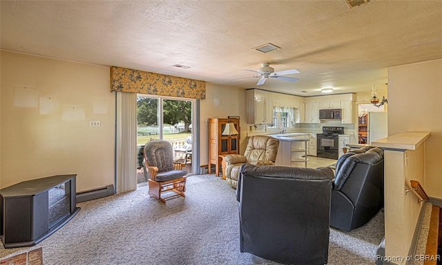 68 Family Ln, Cobbs Creek, VA 23035 - living room with a baseboard heating unit, light carpet, a ceiling fan, and baseboards