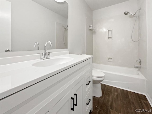 bathroom featuring toilet, vanity, shower / bath combination, and wood finished floors