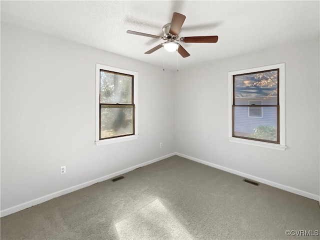 spare room with ceiling fan, carpet flooring, and baseboards