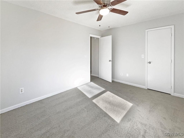 unfurnished bedroom featuring carpet, baseboards, and a ceiling fan