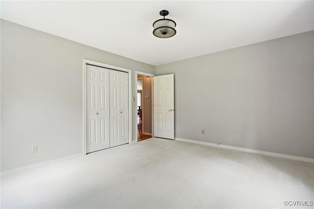unfurnished bedroom with a closet, baseboards, and light carpet
