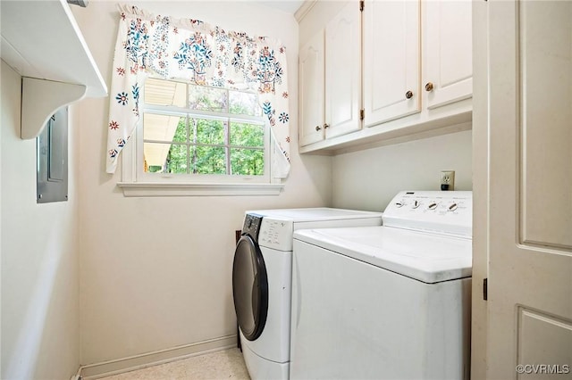 washroom featuring washing machine and dryer, cabinet space, and baseboards
