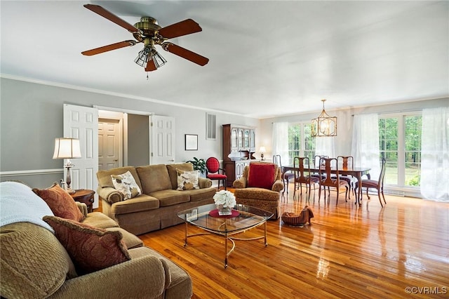 living area featuring wood finished floors, a ceiling fan, and ornamental molding