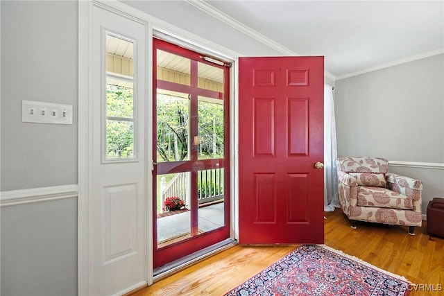 entryway with wood finished floors and crown molding