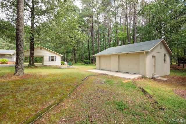 view of grassy yard with a garage and an outbuilding