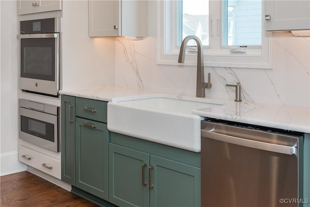 12543 N Readers Ln, Manakin Sabot, VA 23103 - kitchen with appliances with stainless steel finishes, green cabinetry, tasteful backsplash, a sink, and dark wood finished floors