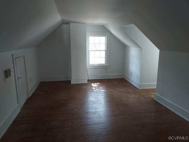 additional living space featuring wood finished floors, lofted ceiling, and baseboards