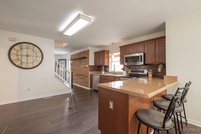 7418 Whirlaway Dr, Midlothian, VA 23112 - kitchen with stainless steel appliances, a breakfast bar, tasteful backsplash, dark wood-type flooring, and a peninsula