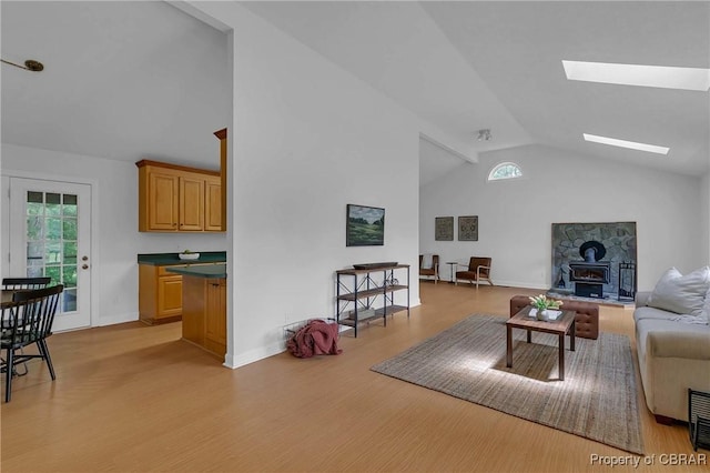 2480 Lees Neck Farm Rd, Saluda, VA 23149 - living area with a wood stove, light wood-style flooring, a skylight, high vaulted ceiling, and baseboards