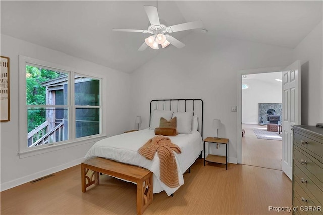 2480 Lees Neck Farm Rd, Saluda, VA 23149 - bedroom featuring vaulted ceiling, light wood-style flooring, baseboards, a ceiling fan, and a wood stove