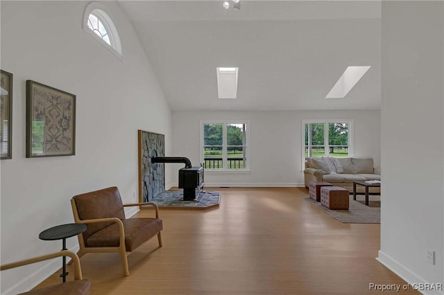 2480 Lees Neck Farm Rd, Saluda, VA 23149 - sitting room with a skylight, a wood stove, wood finished floors, baseboards, and high vaulted ceiling