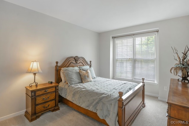 bedroom with light colored carpet and baseboards
