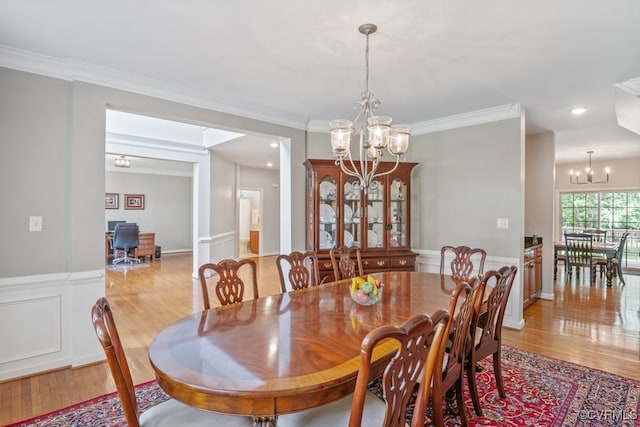 dining area with a chandelier, light wood-type flooring, crown molding, and recessed lighting