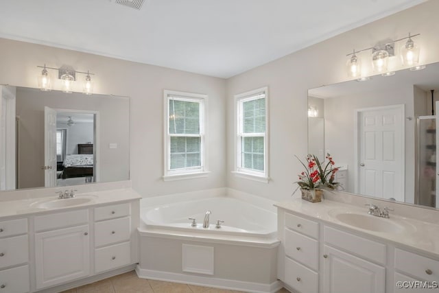 ensuite bathroom featuring a bath, two vanities, and tile patterned floors