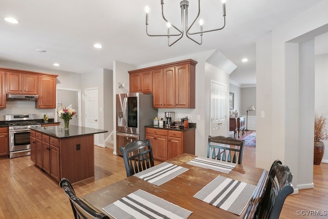 kitchen featuring appliances with stainless steel finishes, under cabinet range hood, dark countertops, light wood finished floors, and recessed lighting