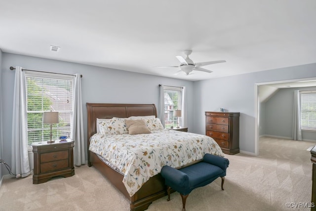 bedroom featuring light colored carpet, a ceiling fan, and baseboards